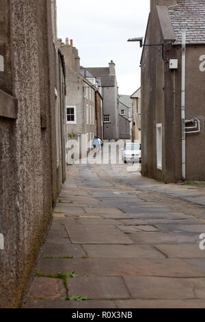 Alfred Street in Stromness, Orkney con vecchie pietre per pavimentazione da una cava in Orphir e ciottoli nel centro della strada. Foto Stock