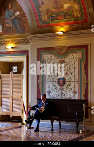 Washington DC. Giugno 2013. Un politico prende un caffè e giornale break out nell'arte Brumidi corridoio decorato durante la legislazione. Foto Stock