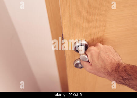 Mano maschio aprendo la porta, close up con il fuoco selettivo Foto Stock