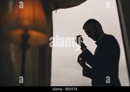 Elegante lo sposo in una camera di hotel Foto Stock