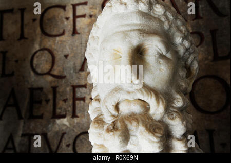 Busto di imperatore Commodo nei musei Capitolini di Roma. Sullo sfondo antica iscrizione in latino. Roma, Italia Foto Stock