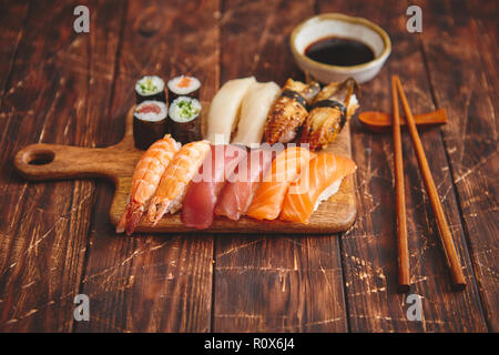 Sushi set. Diversi tipi di rotoli di sushi su legno scheda servente Foto Stock