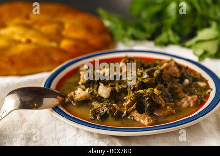 Chashushuli circondato da verdure su una tavola di legno Foto Stock