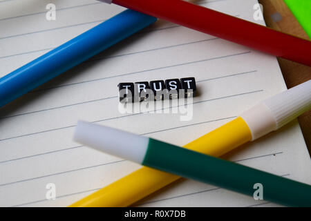 Messaggio di fiducia scritto su blocchi di legno. Istruzione e motivazione concetti. Croce immagine elaborata su sfondo verde Foto Stock