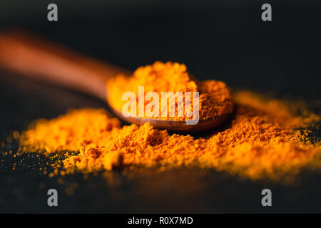 Lo zafferano in un cucchiaio su uno sfondo scuro, il fuoco selettivo, macro shot, profondità di campo Foto Stock