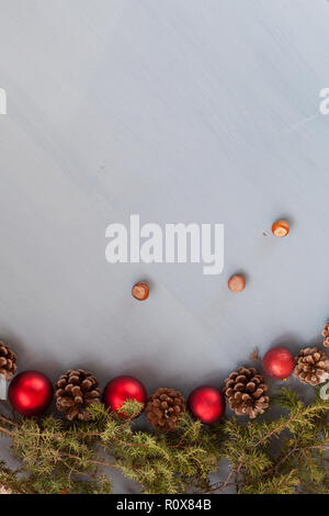 Albero di natale coni dado rosso palle su sfondo grigio Foto Stock