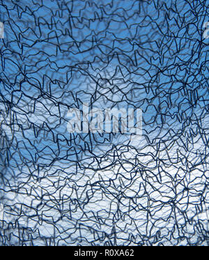 I thread di interallacciamento contro sky. Maglia tessuta da fili nero su blu e sfondo bianco. texture astratta Foto Stock