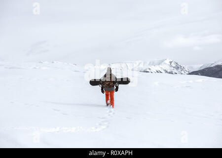Snowboarder va in salita a ski tour in montagna Foto Stock