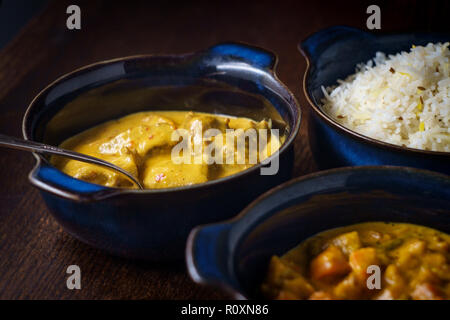 Cremosa cibo indiano agnello rogan josh e Korma vegetale con il bianco del riso basmati in scodelle di servizio Foto Stock