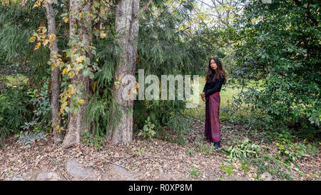 Donna Thai in piedi nella foresta accanto agli alberi di sarong Foto Stock