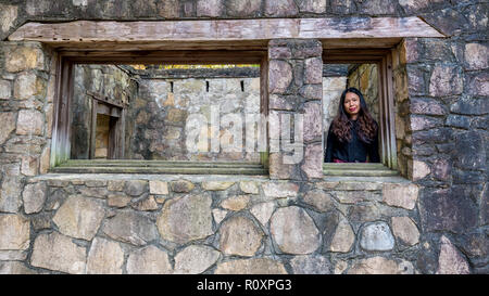 Donna in piedi nella finestra di biglietteria in anfiteatro Foto Stock