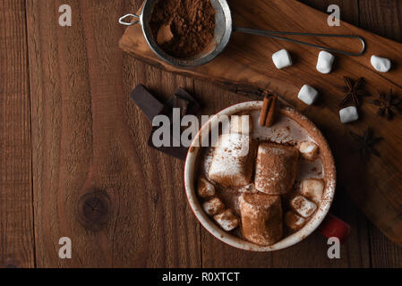 Scatto dall'alto di una grande tazza di cioccolata calda con marshmallows su un legno rustico tavolo da cucina, con copia spazio. Foto Stock