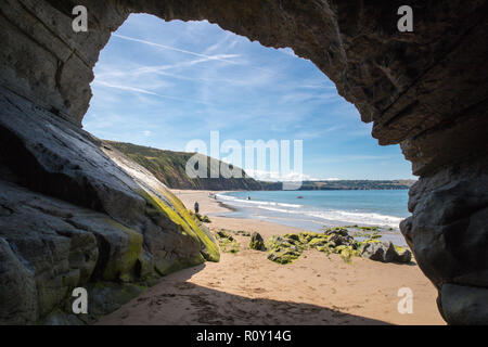 Grotta sulla spiaggia sabbiosa in Penbryn, Cardigan Bay, il Galles. Preso in una giornata di sole quando la spiaggia era vuota. Foto Stock