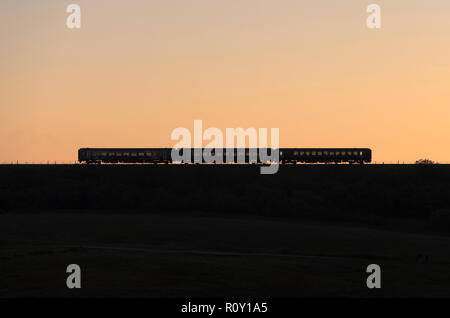 Arriva Nord classe rampa 153 + 158 sprinter treni a Ribblehead sull'accontentarsi di Carlisle linea ferroviaria al tramonto Foto Stock