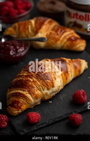Croissant circondato con lamponi Confettura di lamponi e nutella Foto Stock