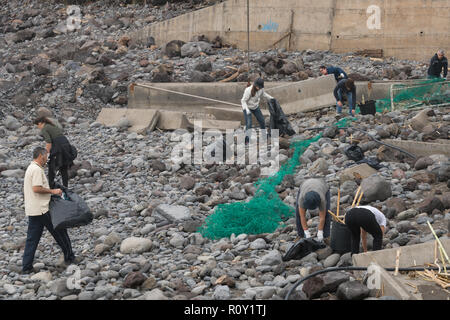 Il volontariato locale di persone la pulizia della spiaggia dopo una tempesta a Ponta do Sol, di Madera Foto Stock