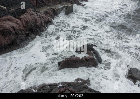 Vista del mare con le onde che si infrangono sulle rocce a Ponta do Sol pier Foto Stock