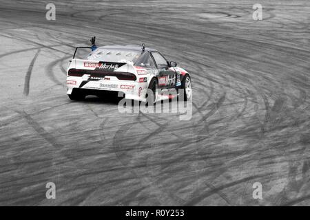 Auto da corsa onde pilota dopo la deriva Foto Stock