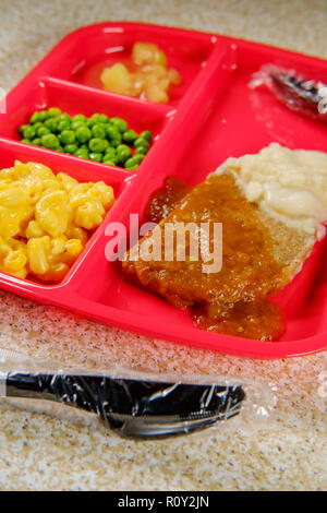 Scuola elementare il pranzo salisbury steak sul vassoio con piselli maccheroni e formaggio e salsa di mele Foto Stock