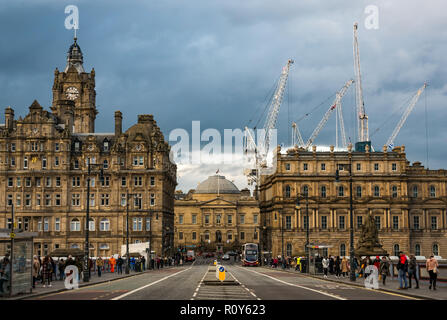 Edimburgo, Scozia, Regno Unito, 7 novembre 2018. Regno Unito: Meteo nuvole scure si radunano nel centro della città di edifici. The Balmoral Hotel torre dell orologio sul North Bridge è occupato con pedoni. Gru per edilizia nel nuovo St James torreggiante di sviluppo al di sopra del tetto Foto Stock