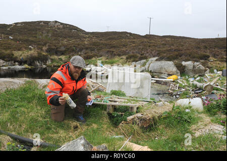 Bergen, Norvegia. Xxiv Maggio, 2018. Eivind Bastesen esamina garbage su una piccola isola vicino alla città di Bergen. Per decenni la corrente ha lavato a terra qui ciò che le persone hanno incautamente gettato via. (Zu dpa 'Garbage dump in mare - Plastica sfigura costa norvegese') Credito: Sigrid Harms/dpa/Alamy Live News Foto Stock