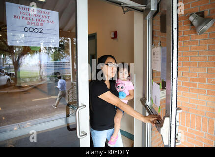 Houston, Stati Uniti d'America. 6 Nov, 2018. Elettore Ms. Rosales passeggiate fuori da una stazione di polling con sua figlia dopo la colata il suo voto a Houston, Texas, Stati Uniti, nov. 6, 2018. Gli elettori' desiderio di una rappresentanza più equilibrata nel Congresso ha abilitato il partito democratico per ottenere due sedi della Casa dei Rappresentanti in Texas negli Stati Uniti elezioni di mid-term terrà martedì. Per andare con funzione: democratici di fare progressi simbolici in Texas come elettori si aspettano le modifiche Credito: Wang Ying/Xinhua/Alamy Live News Foto Stock