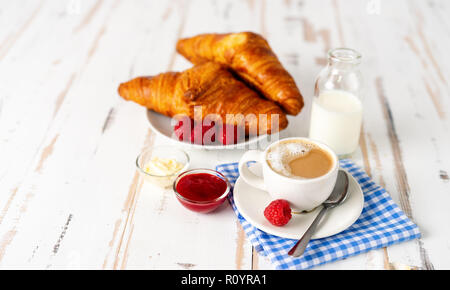 Tazza di caffè e due cornetti per la prima colazione sul tavolo bianco Foto Stock