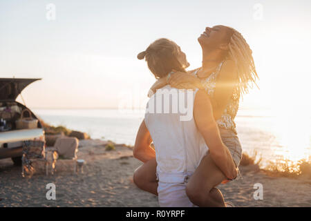 Forte uomo atletico tenendo la sua attraente donna sulle sue mani Foto Stock