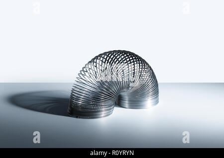 Slinky toy piegata a semicerchio in forma, studio still life Foto Stock