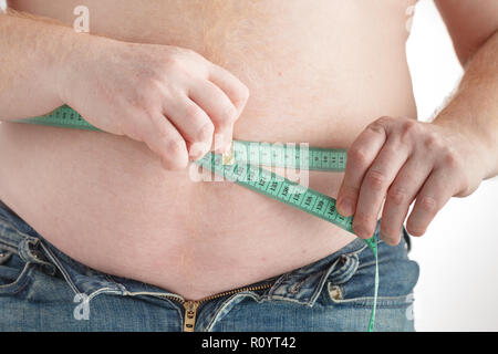 Fat Man check out il suo corpo grasso con nastro di misurazione per il grasso o l'obesità sfondo Foto Stock