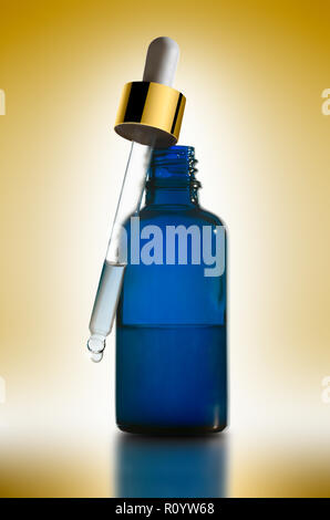 Essenziale il trattamento di bellezza in blu flacone contagocce con pipetta contro sfondo giallo, studio still life Foto Stock