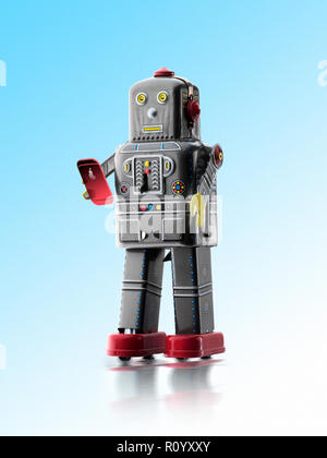 Vintage retrò wind-up tin robot giocattolo texting sullo smartphone, studio shot Foto Stock