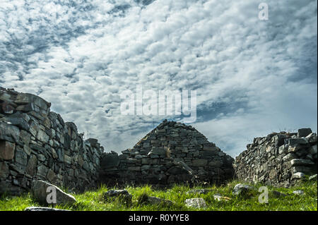 Vista del cielo drammatico e abbandonata delle Ebridi croft casa sulla costa del lato ovest di Lewis Foto Stock