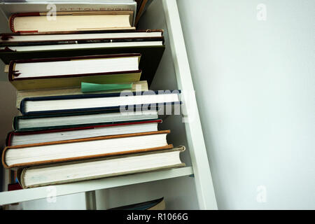 Fotografia dei lati di una pila di libri ha salvato su un ripiano bianco, nessuna copia Foto Stock
