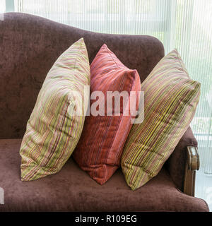 A strisce colorate di cuscini sul divano rosso in luxury living room interior Foto Stock