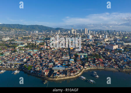 Vista rialzata della città di Cebu la mattina presto. L'immagine è poco informale Insediamenti in primo piano con città moderna urbana Foto Stock