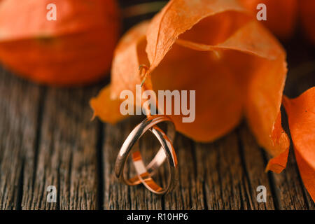 Gli anelli di nozze su rosso Foglie di autunno Foto Stock