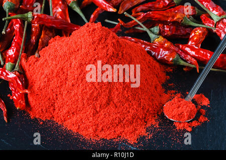 Cayenne pepe rosso in polvere nella ciotola bianco su sfondo di legno Foto Stock