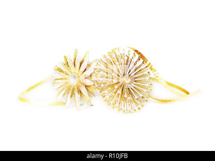 Due oro ornata di fiori di metallo con nastro in mezzo di tiro, sfondo bianco Foto Stock