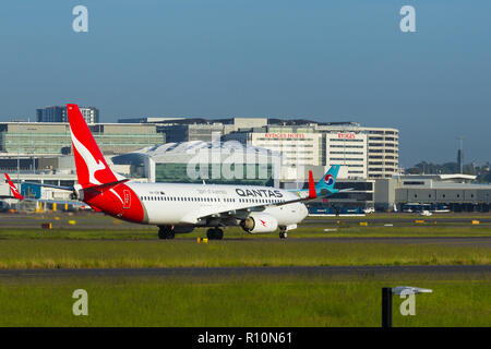 Dettaglio da Sydney (Kingsford Smith) Aeroporto di Sydney, Australia, guardando verso il terminal Internazionale sul lato occidentale dell'aeroporto. Nella foto: un Qantas Boeing 737-800 (indicativo di chiamata VH-VZM taxying). Foto Stock