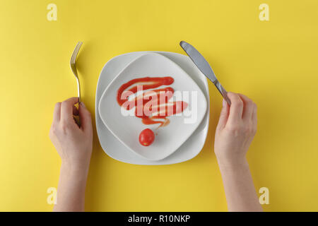 Donna due mani hanno un cucchiaio e forchetta e piatto bianco su sfondo giallo Foto Stock
