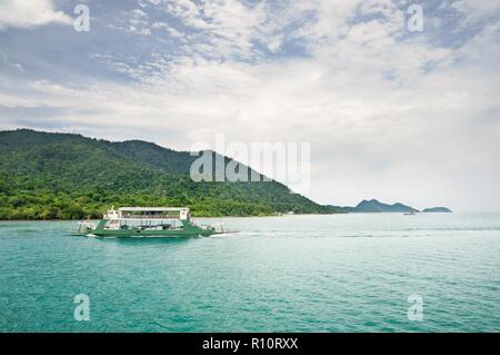 Paesaggio con il turchese mare tropicale, carico del traghetto e tropical Koh Chang island sull orizzonte in Thailandia Foto Stock