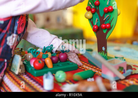 Ragazzo concentrato colorato mette le monete durante ABA Foto Stock