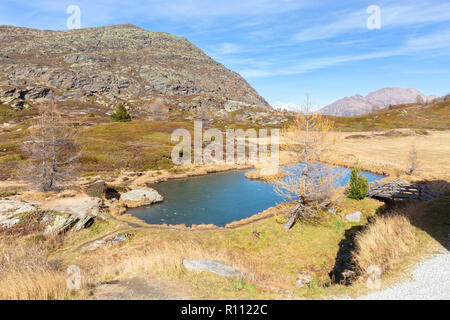 Un piccolo laghetto congelato e il nuovo Ospizio in cima al passo del Sempione. Simplonpass, Canton Vallese, Svizzera. Foto Stock