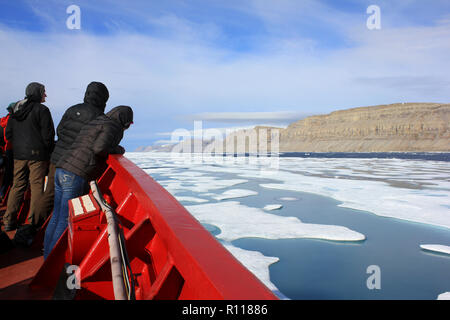 Gli scienziati a prua della CCGS Amundsen come ella irrompe attraverso il ghiaccio in Lancaster Suono, Canada Artico Foto Stock