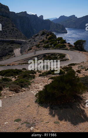 Strada tortuosa avvicinando il lontano de Formentor faro, Maiorca, isole Baleari, Spagna. Foto Stock