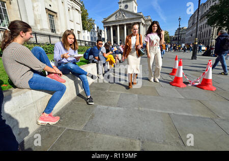 Le persone in un momento di relax a ora di pranzo di fronte alla National Gallery in Trafalgar Square a Londra, Inghilterra, Regno Unito. Foto Stock