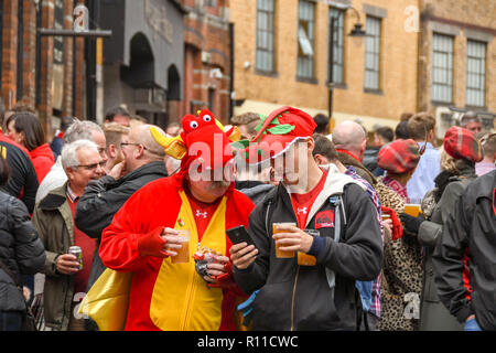 CARDIFF, GALLES - NOVEMBRE 2018: Due sostenitori gallesi del rugby che bevono e parlano in una folla fuori da un pub nel centro di Cardiff prima di una partita Foto Stock