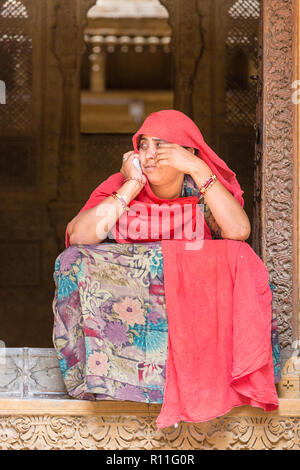 Un locale di Rajasthani donna seduta al Patwon-Ki Haveli nel deserto città di Jaisalmer nello stato del Rajasthan in India occidentale Foto Stock