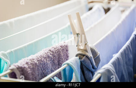 I diversi tipi di vestiti lasciati appesi per asciugare mantenuta da un clothespin su uno stenditoio Foto Stock
